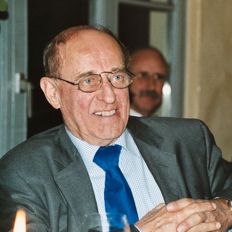 Klaus Doderer, im Anzug, am Tisch